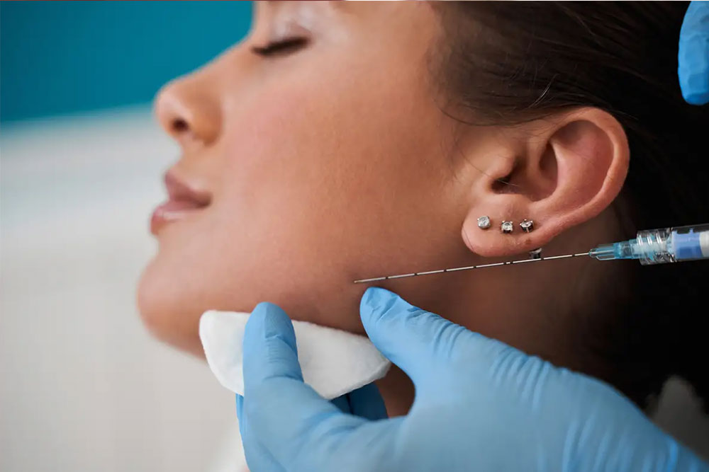 Woman getting botox treatment to help ease pain caused by TMJ syndrome